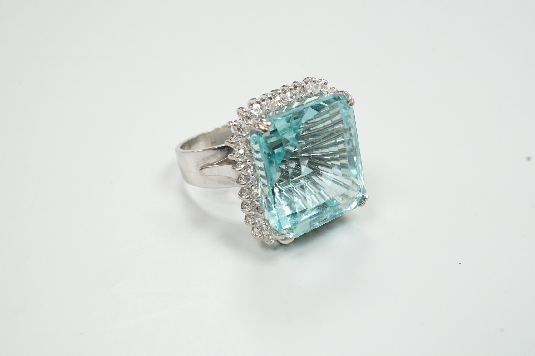 A modern 18ct white metal, simulated aquamarine and diamond chip cluster set dress ring, size P/Q, gross weight 16.3 grams